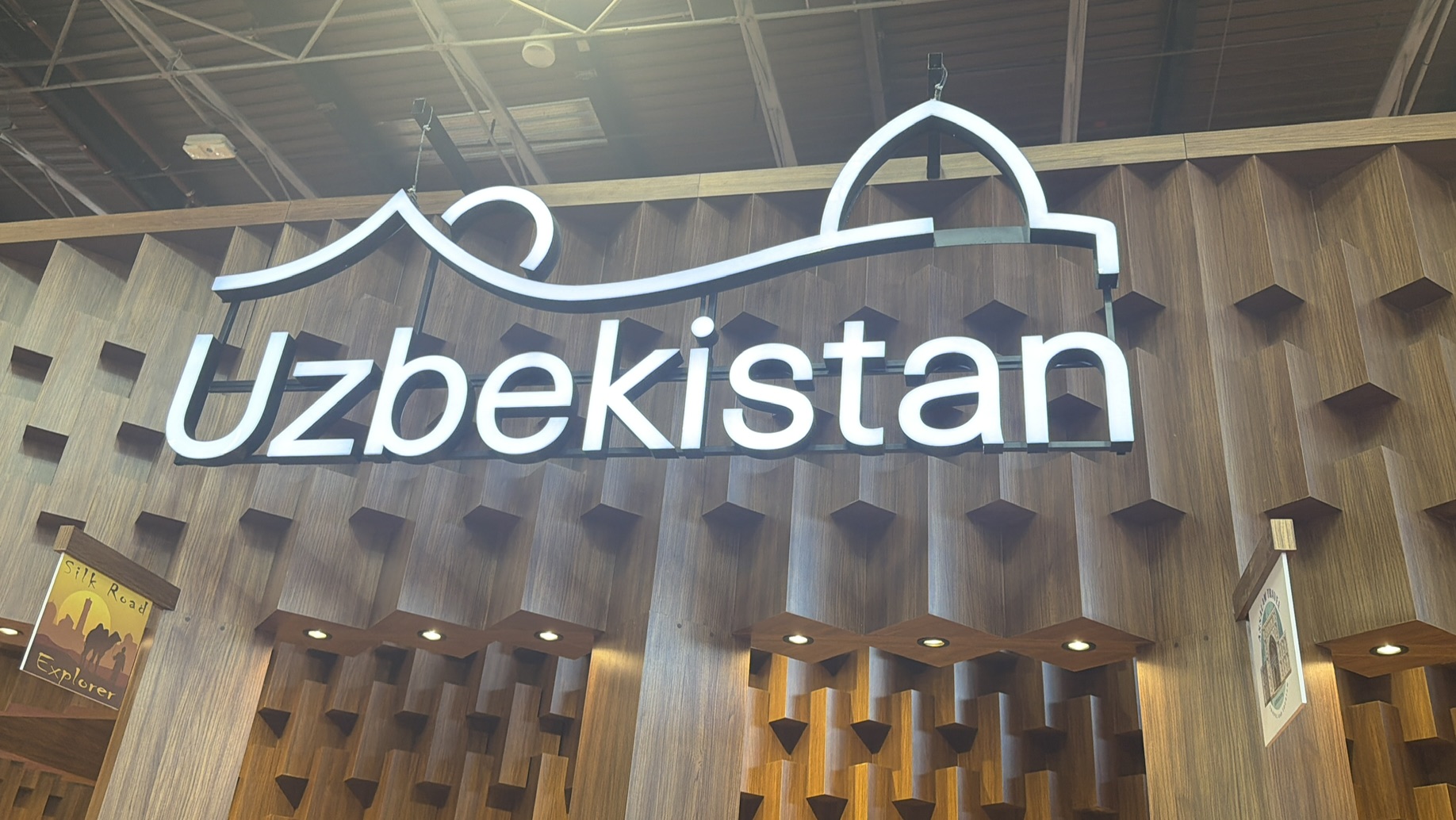 Détail du stand de l’Ouzbékistan à l’IFTM Top Resa 2026, avec l’inscription « Uzbekistan » devant un décor géométrique en bois inspiré de l’architecture ouzbèke.